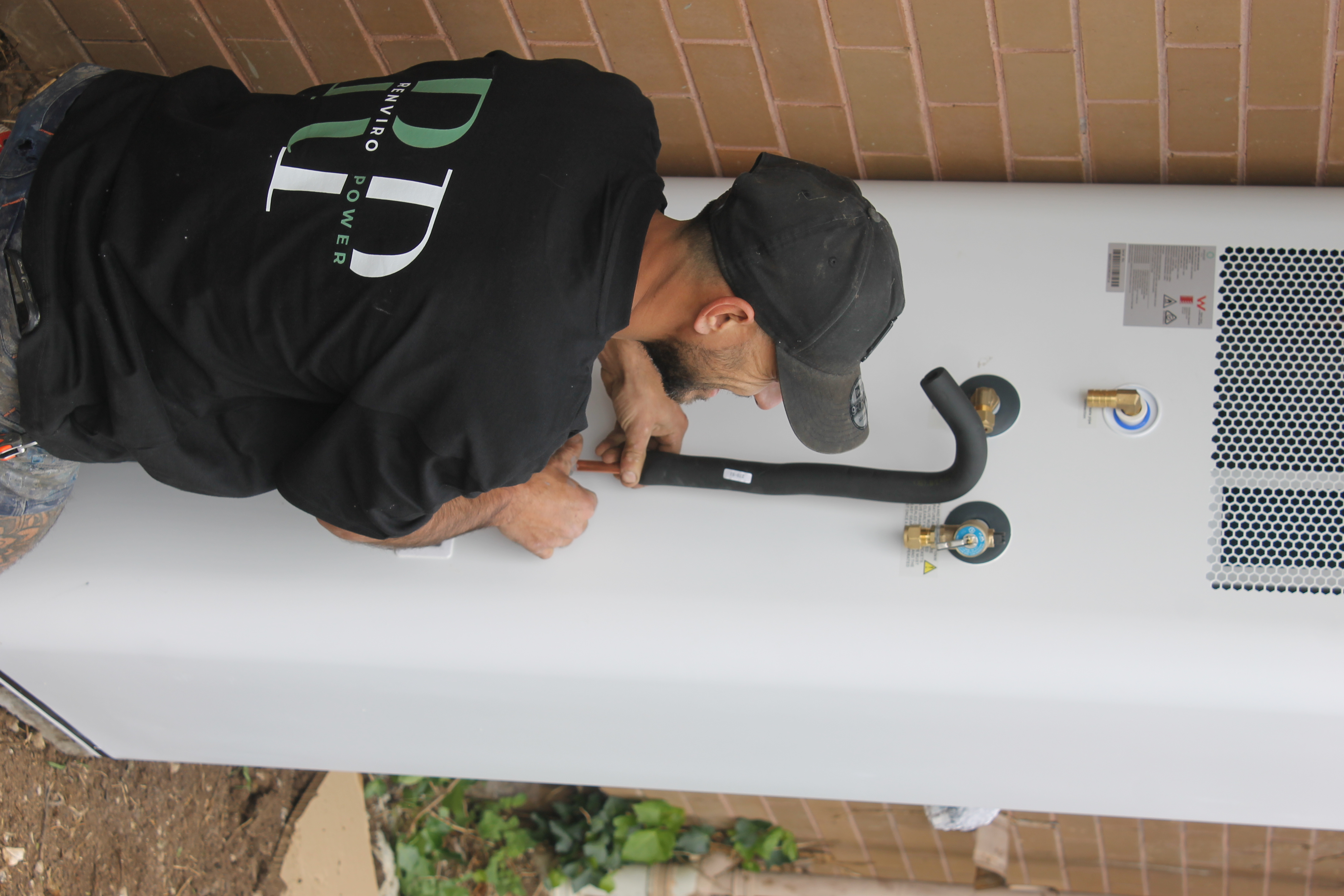 Renviro Power technician installing an Emerald heat pump in Melbourne